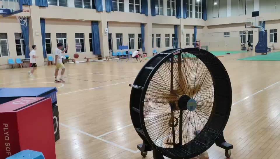 Cấu hình tham khảo cho phòng gym & nhà thi đấu — quạt di động công nghiệp đặt sát biên sân bóng rổ trong nhà thi đấu, thổi trực tiếp vào khu vận động